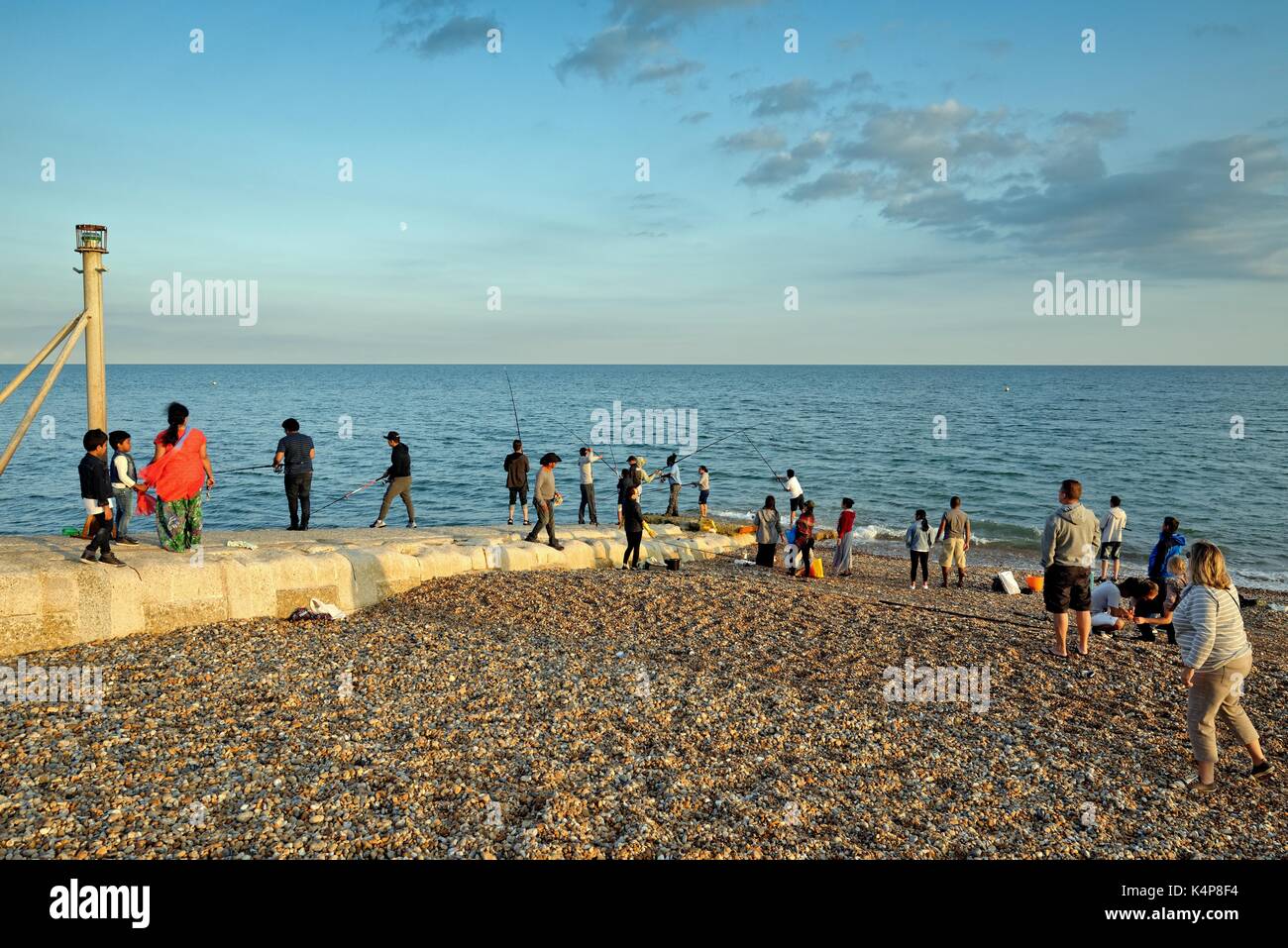 Gruppo misto di persone di pesca sulla spiaggia di Hastings SUSSEX REGNO UNITO Foto Stock