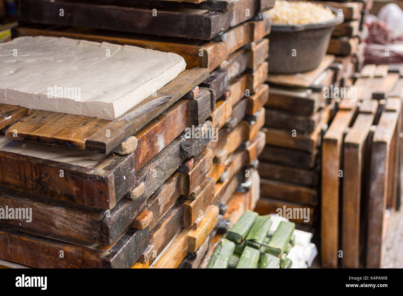 Pile di crudo fresco indonesiano tradizionale tofu tahu in vendita in un mercato locale. Foto Stock