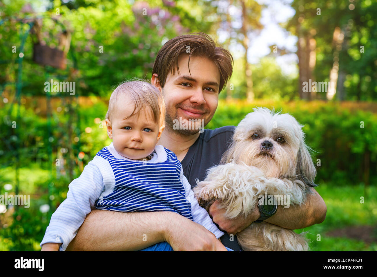 Padre con figlio e cane insieme ritratto in estate il giardino verde Foto Stock