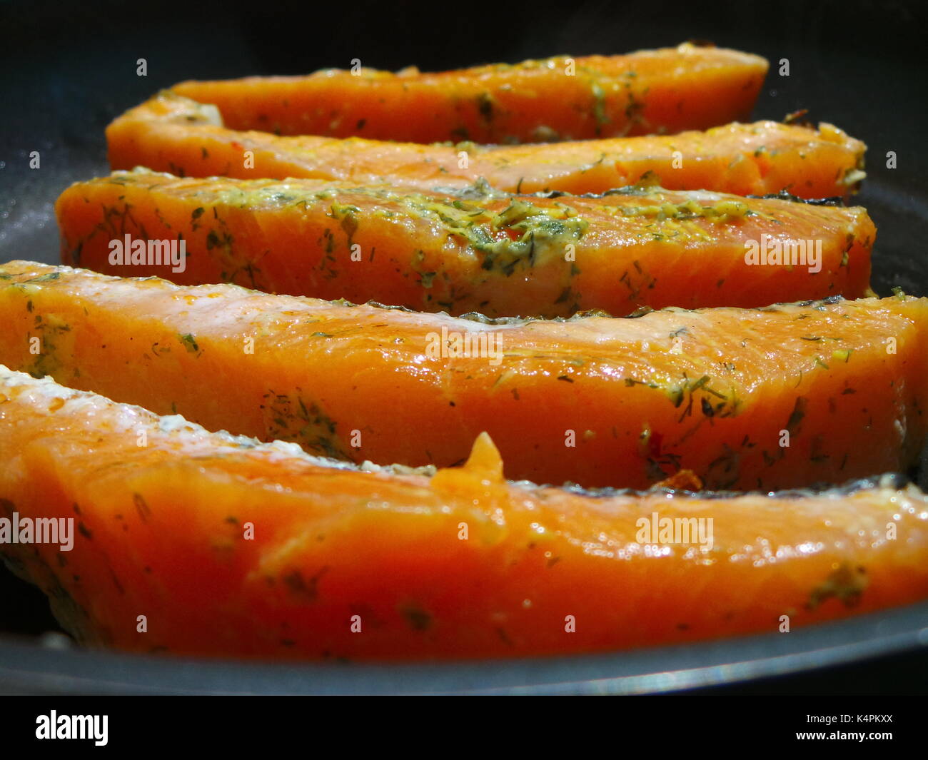 Materie filetto di salmone per friggere in una padella calda Foto Stock