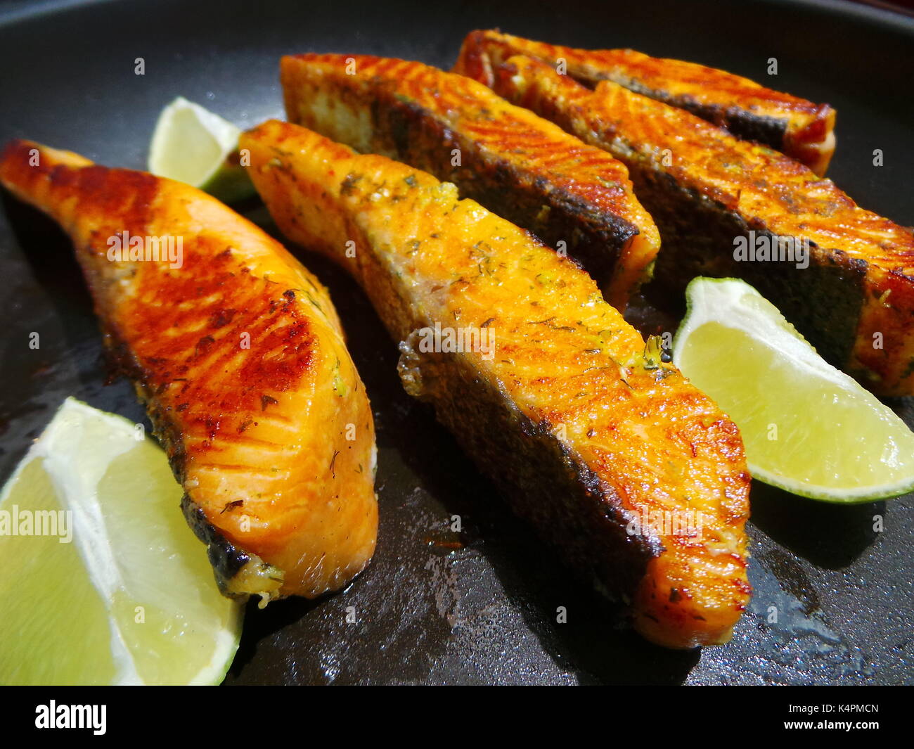 Saporiti filetti di salmone frittura con le fette di limone Foto Stock