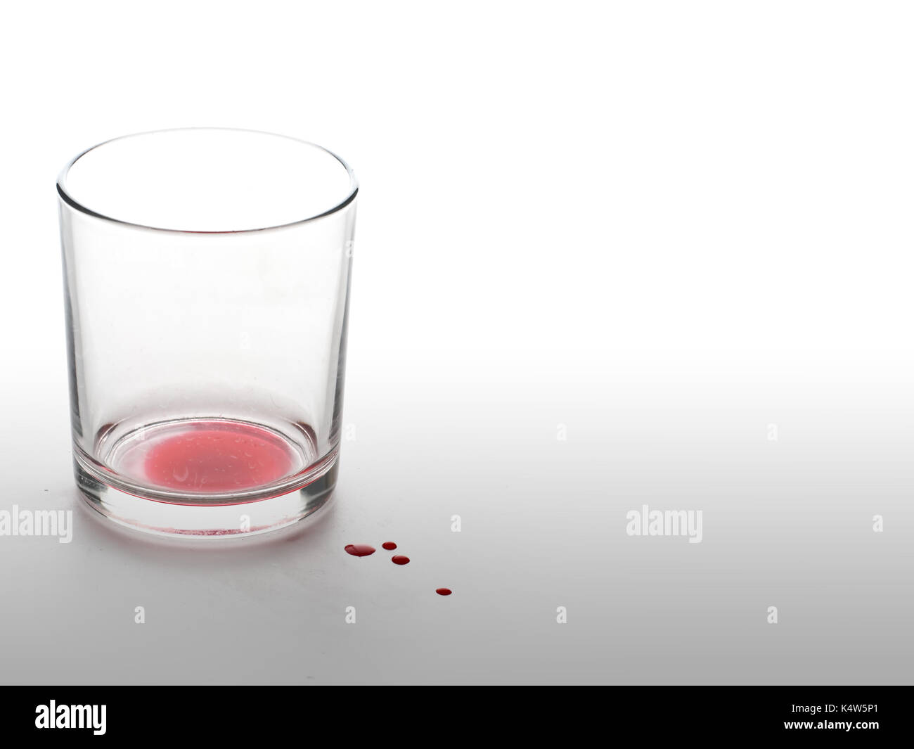 Vetro con liquido rosso come il sangue. dolore o perdita metafora. Foto Stock