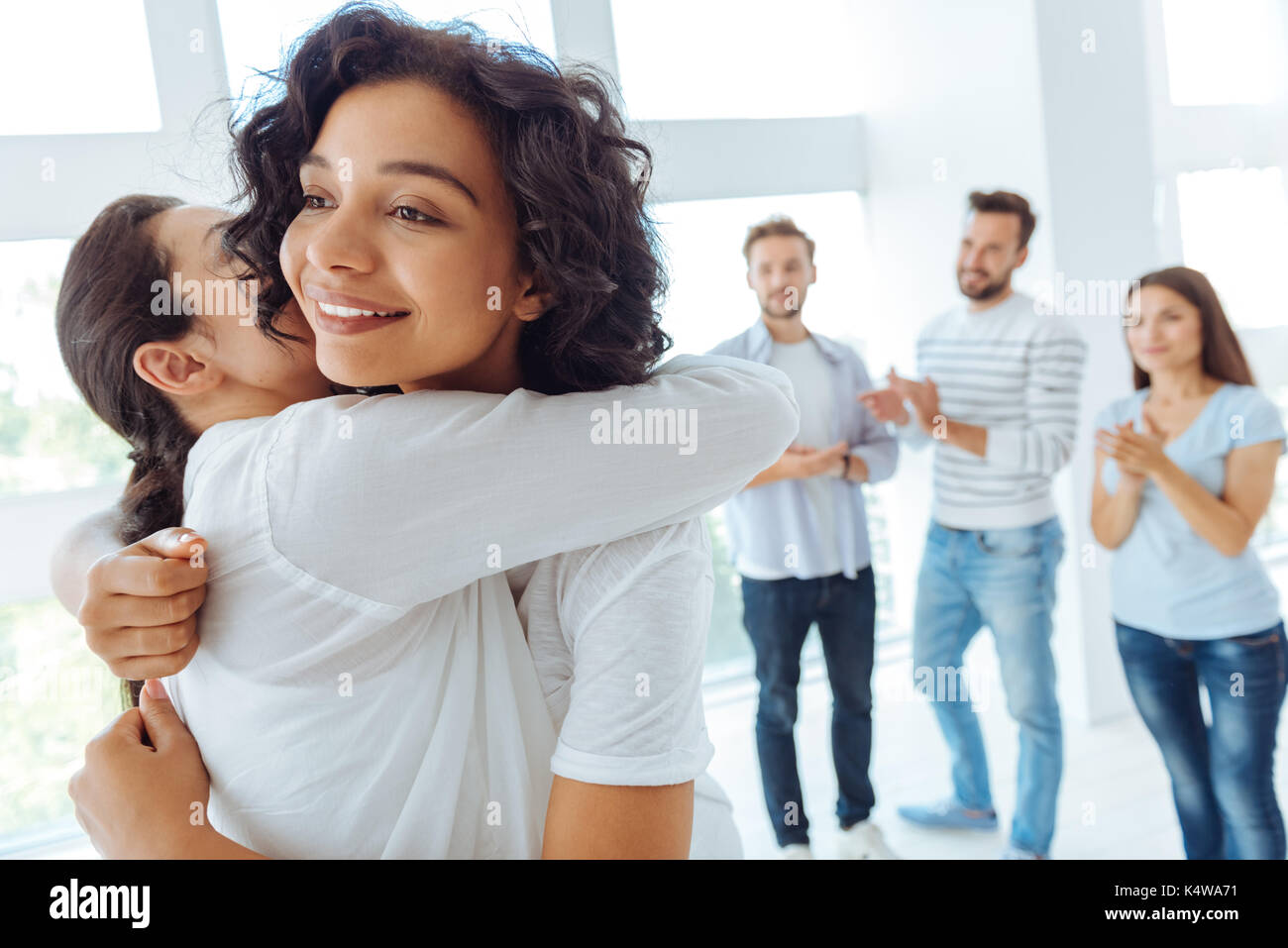 Gioioso donna positivo abbracciando il suo amico Foto Stock