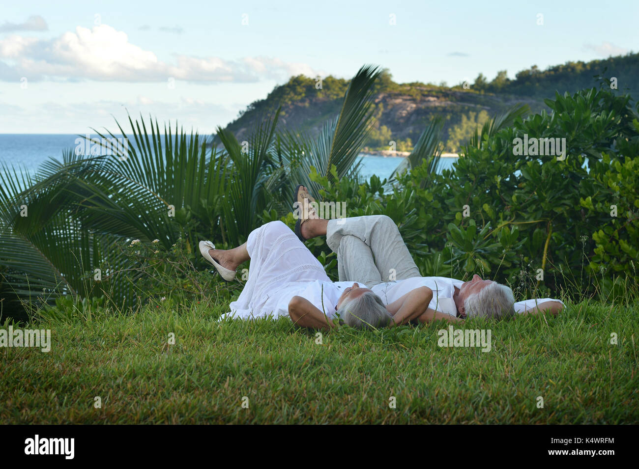 Felice coppia senior giacente su erba verde Foto Stock