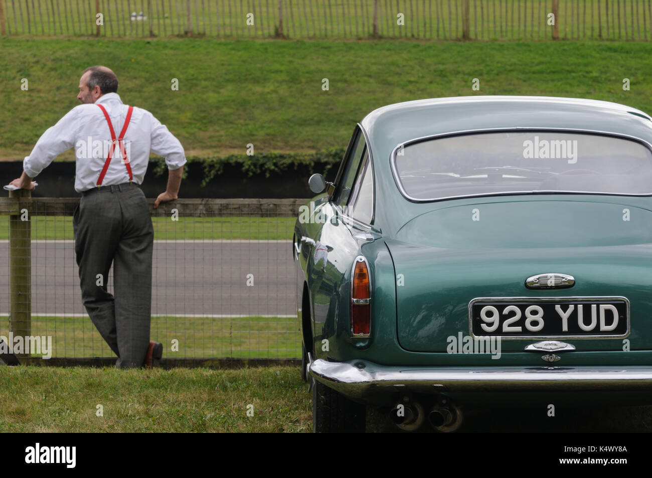 Classic aston martin e uomo in rosso le bretelle a goodwood Foto Stock