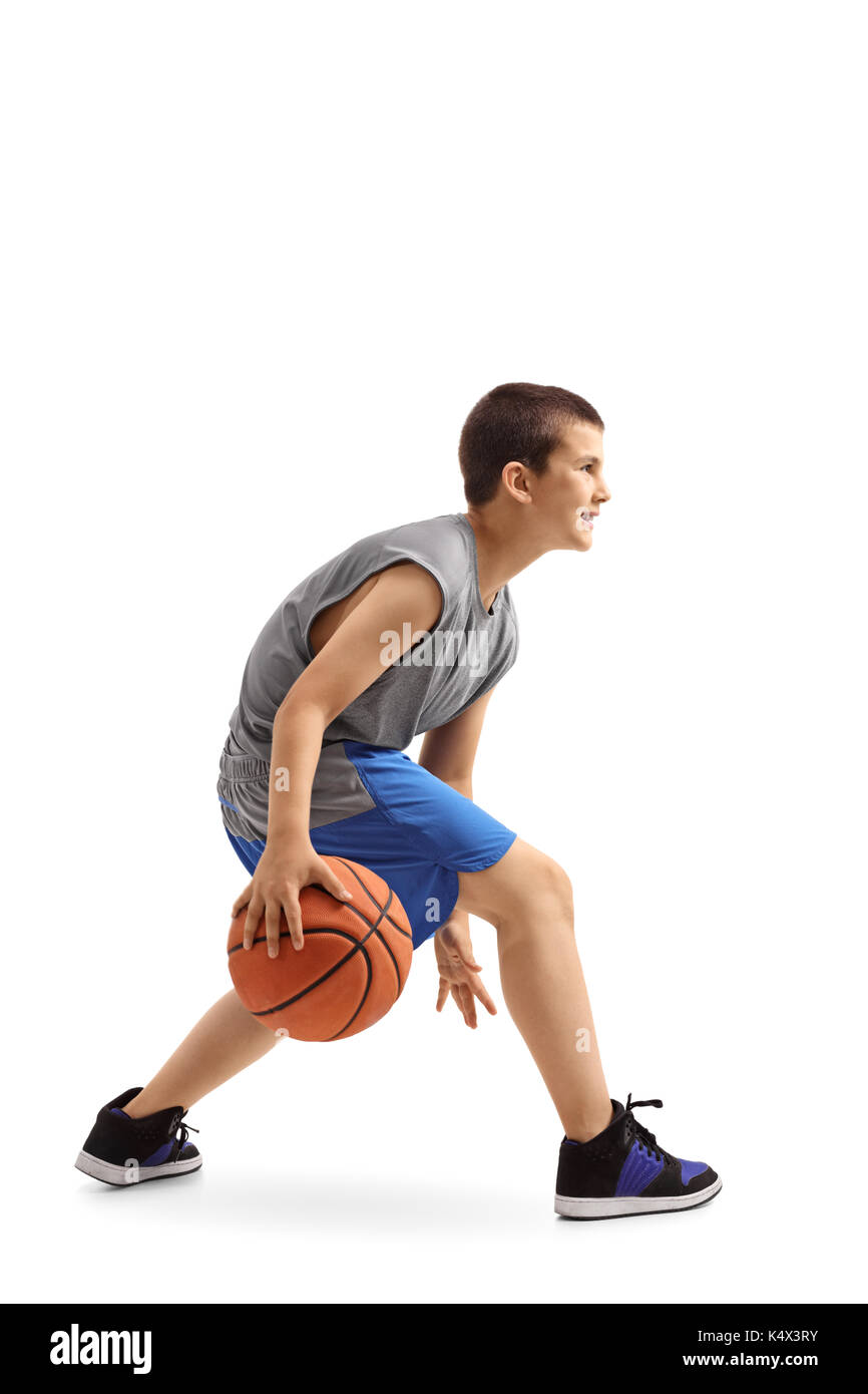 Profilo di colpo un ragazzo dribbling una palla da basket isolato su sfondo bianco Foto Stock
