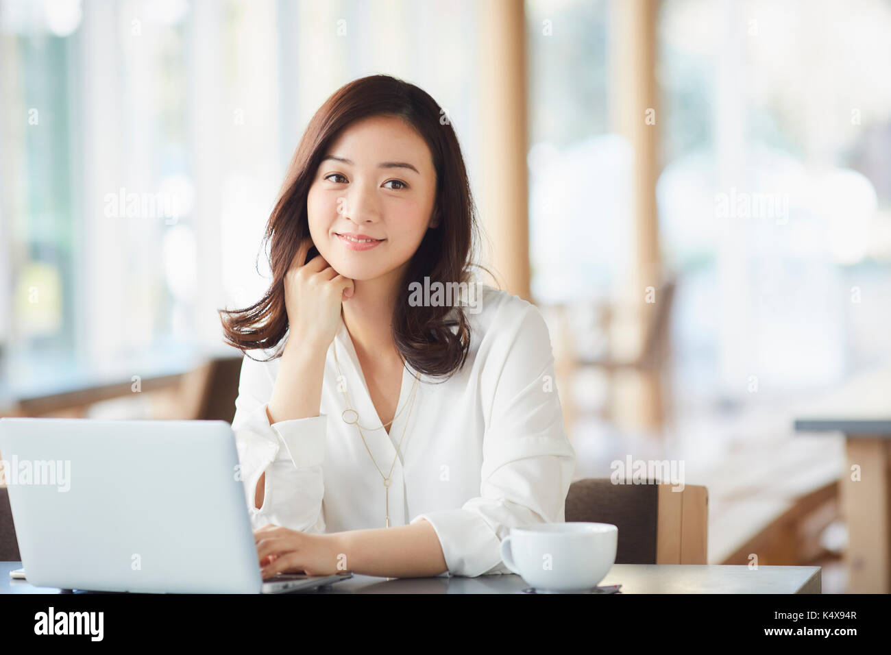 Donna Giapponese con il computer portatile in un elegante cafe Foto Stock
