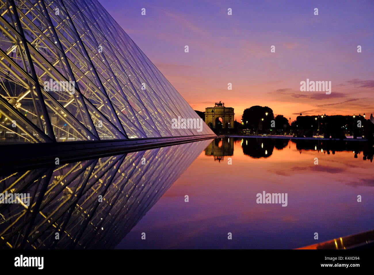 Il Louvre a Parigi di notte come il sole tramonta Foto Stock