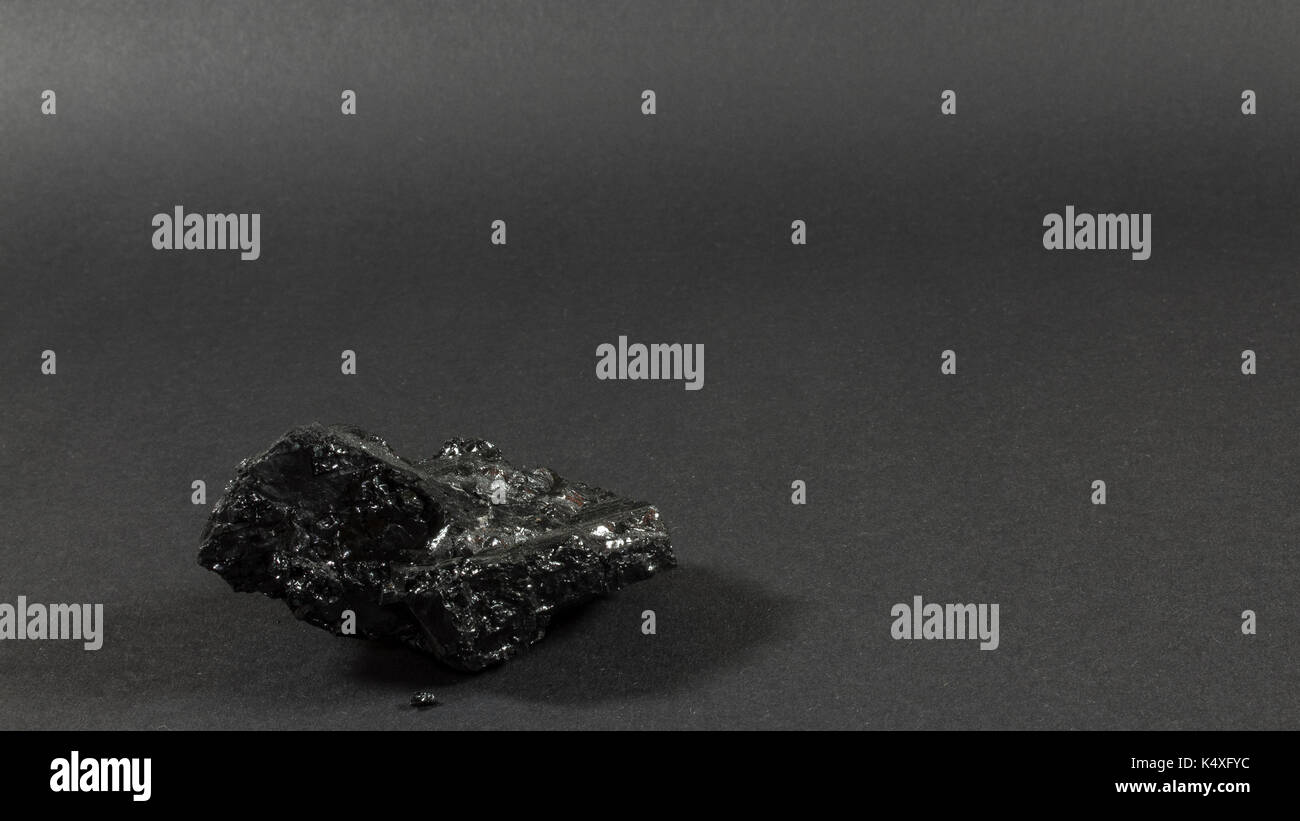 Singola pietra di carbone od sfondo grigio scuro Foto Stock