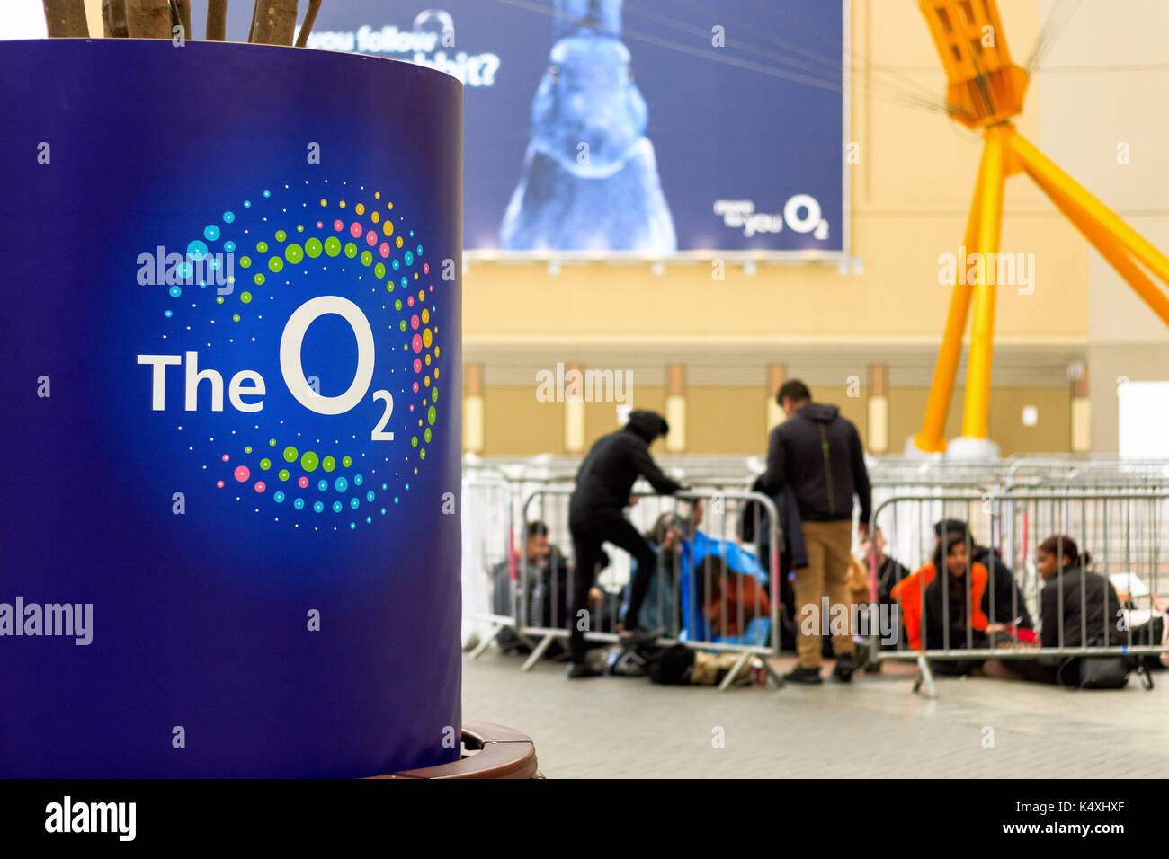 London, Regno Unito - 15 agosto 2017 - interno dell'arena O2 con il suo logo in primo piano e le persone in coda per un evento in background Foto Stock