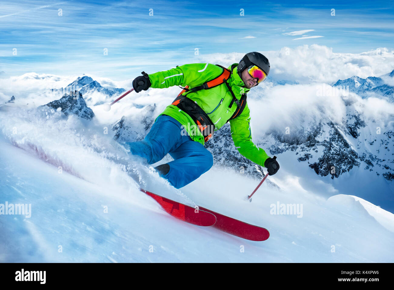Sorprendente colpo di un colorato vestito con rifiniture a sciare sulla neve onda. Foto Stock