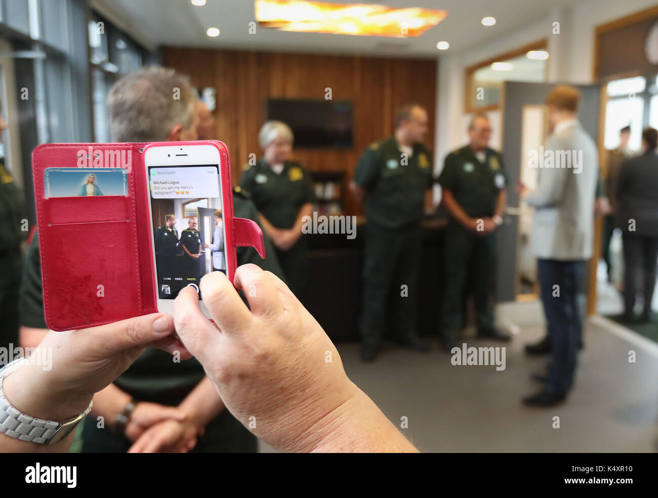 Ambulanza care assistant diane moody prende un telefono foto del principe Harry come egli incontra gli equipaggi di ambulanza durante una visita a ballymena divisione nord hq e stazione di ambulanza durante una visita in Irlanda del Nord. Foto Stock
