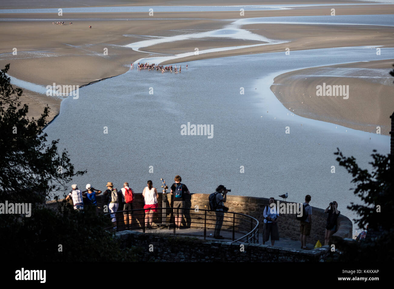 Mont Saint Michel (Saint Michael Mount), Normandia, a nord-ovest della Francia: Escursione nella baia con una guida. Gruppo di escursionisti nella baia con la bassa marea. Croce Foto Stock