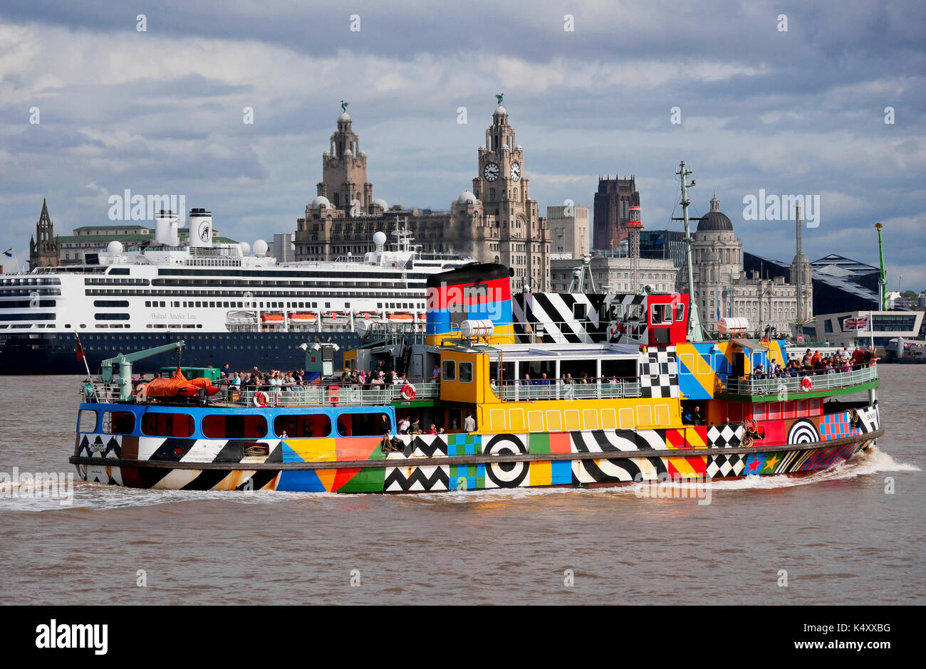 Mersey ferry in livrea dazzle contro lo sfondo del Pier Head e terminale cruiseship Foto Stock