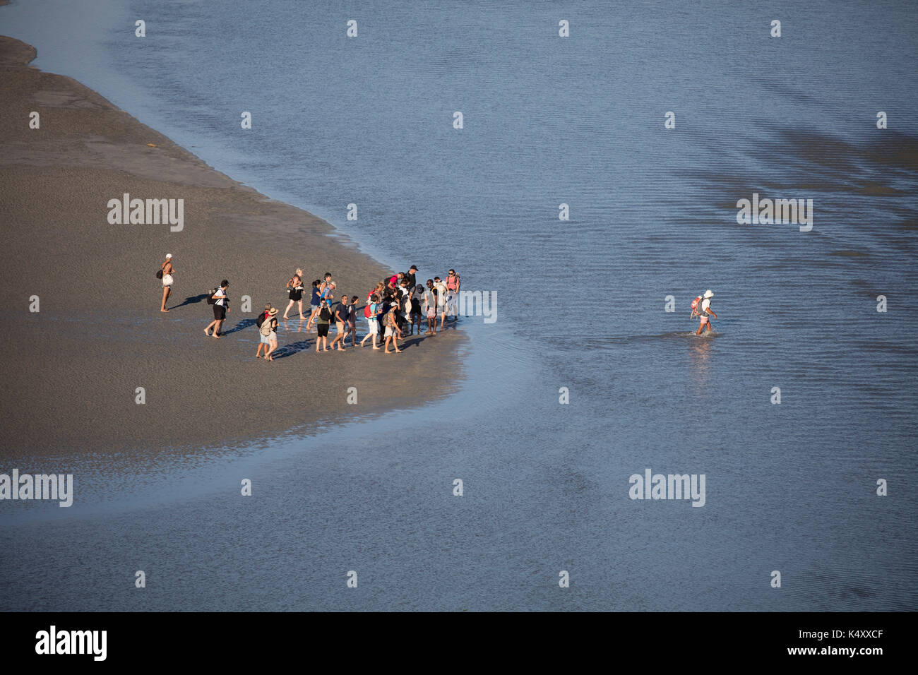 Mont Saint Michel (Saint Michael Mount), Normandia, a nord-ovest della Francia: Escursione nella baia con una guida. Gruppo di escursionisti nella baia con la bassa marea. Cros Foto Stock