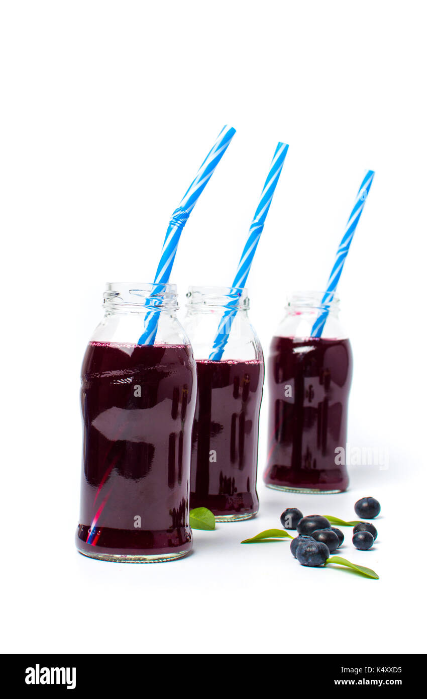 Il succo di mirtillo in bottiglie di vetro isolato su sfondo bianco Foto Stock
