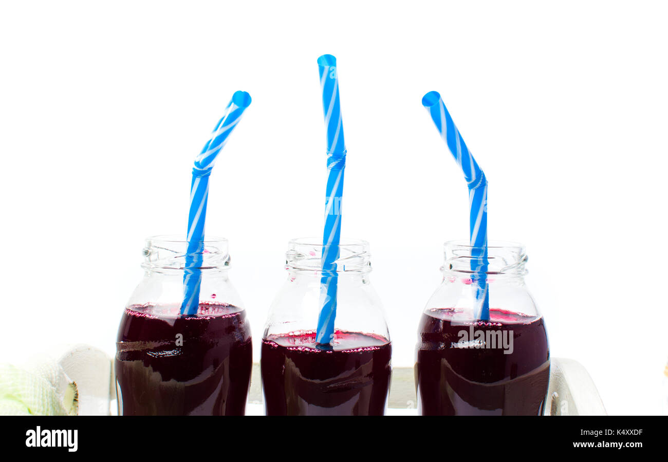 Il succo di mirtillo in bottiglie di vetro isolato su sfondo bianco Foto Stock