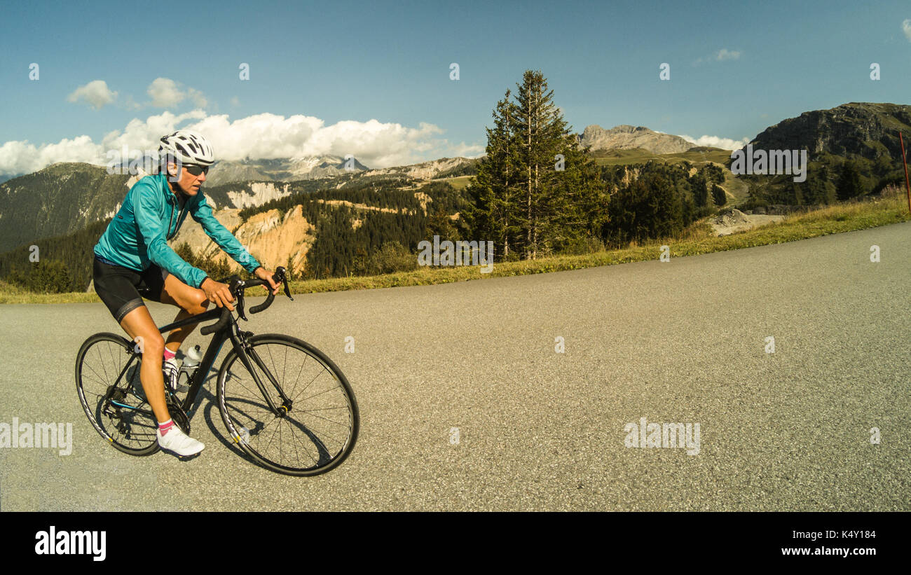 Una donna in bicicletta sulle alpi francesi montagne Foto Stock