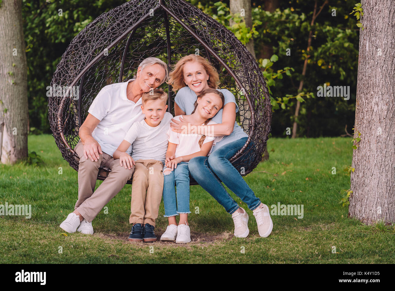 Nonni Felice costeggiata nipoti durante il riposo insieme in giardino Foto Stock