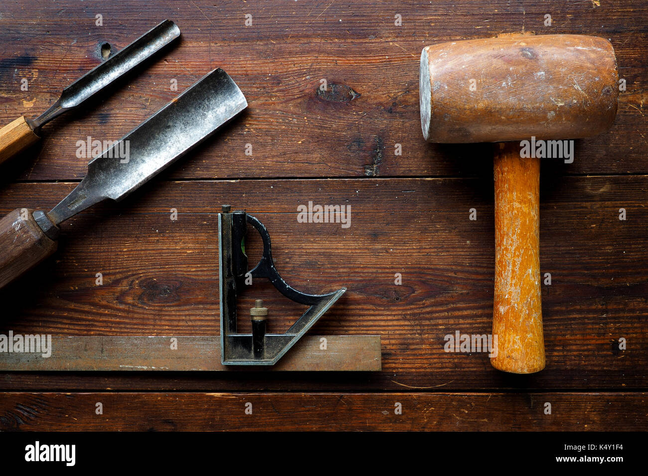 Un mazzuolo e impostare square wit scalpelli di legno sul vecchio tavolo in alto Foto Stock
