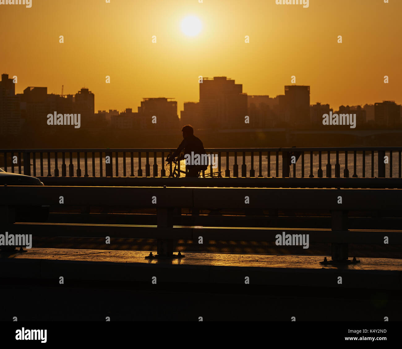 Seul, Repubblica di Corea - 27 settembre 2015: silhouette di un uomo sulla bicicletta che viaggiano sul ponte. Foto Stock