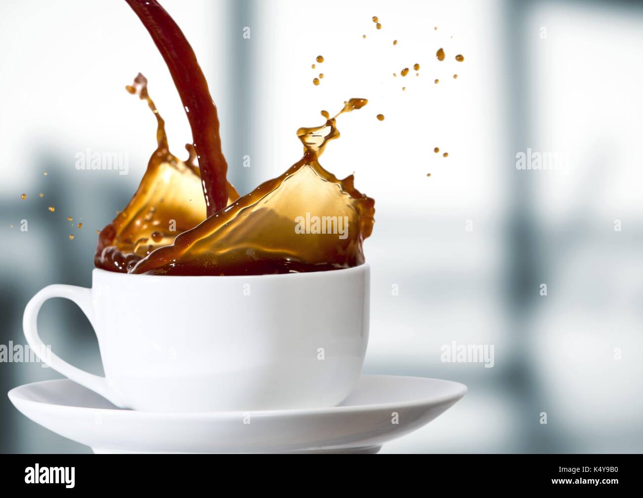 Composito Digitale del caffè è versata nella tazza bianca contro sfocate ufficio grigio Foto Stock