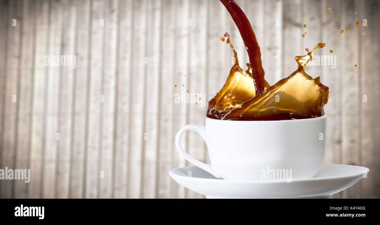Composito Digitale del caffè è versata nella tazza bianca contro sfocate pannello di legno Foto Stock