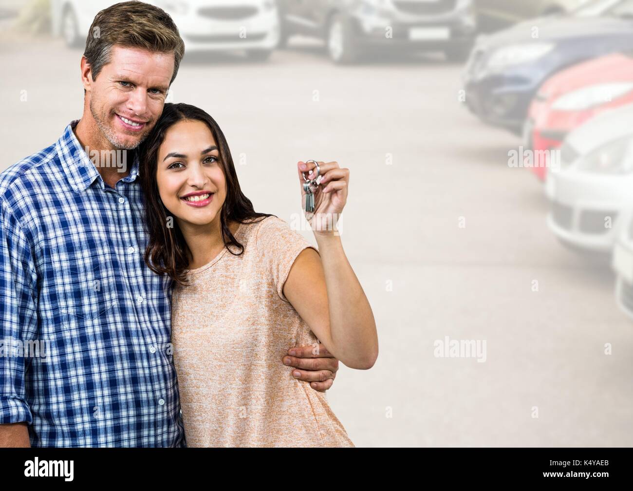 Composito Digitale del giovane in possesso della chiave nella parte anteriore delle vetture Foto Stock