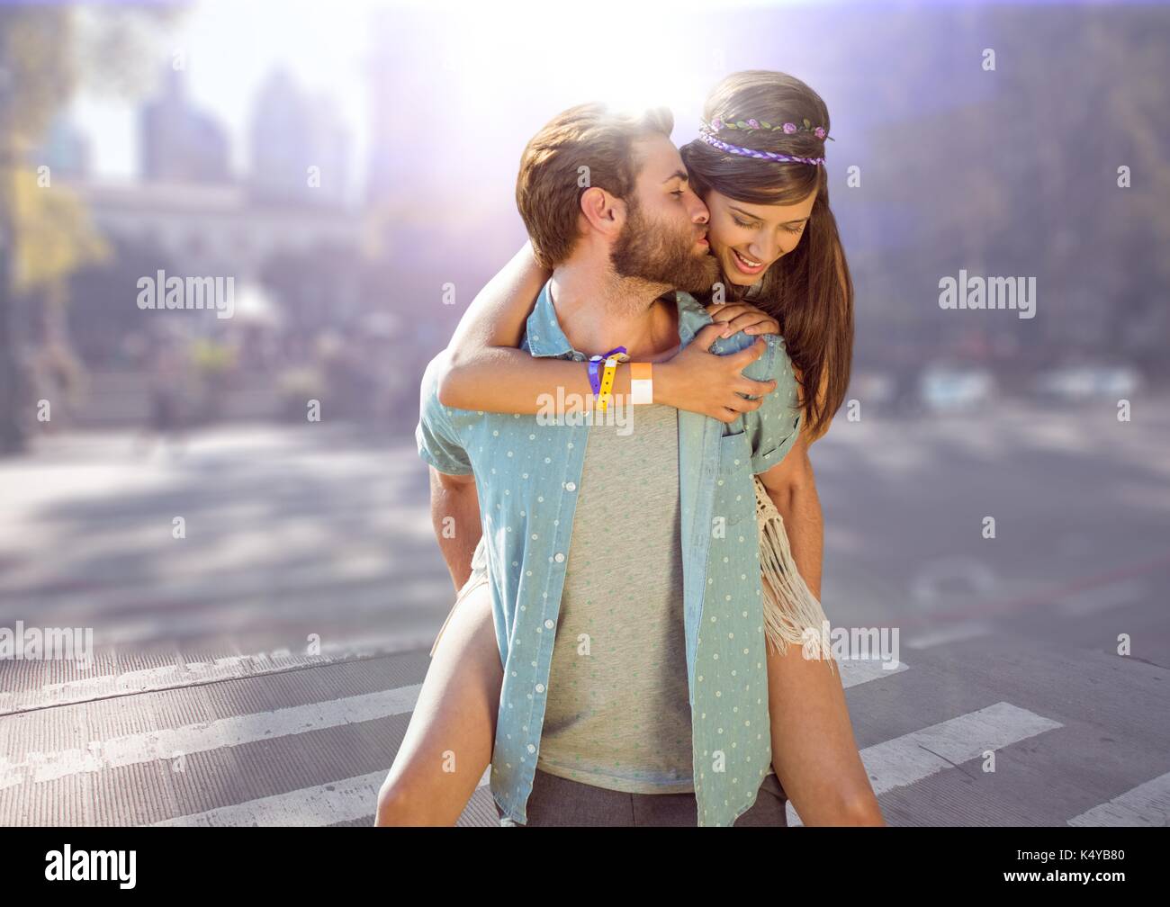 Composito Digitale del giovane piggy back contro sfocata street con flare Foto Stock