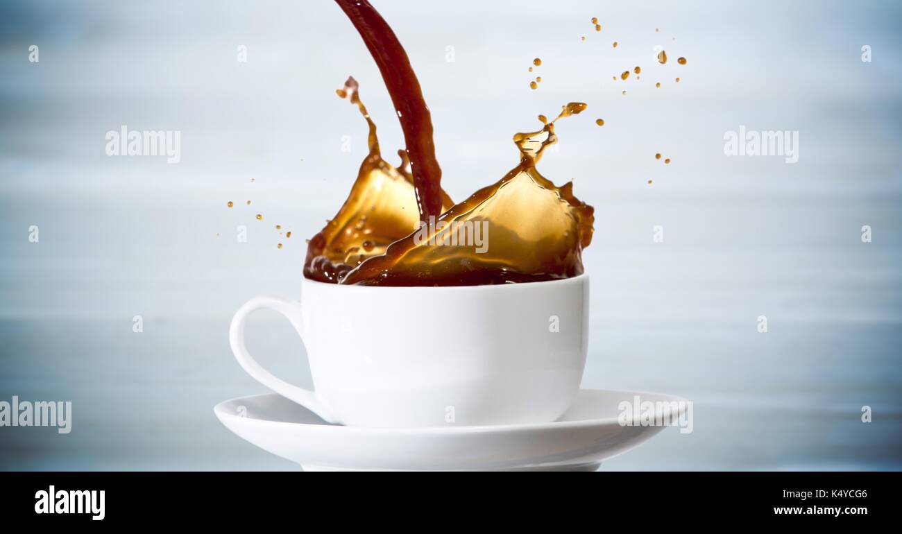 Composito Digitale del caffè è versata nella tazza bianca contro sfocata blu del pannello di legno Foto Stock