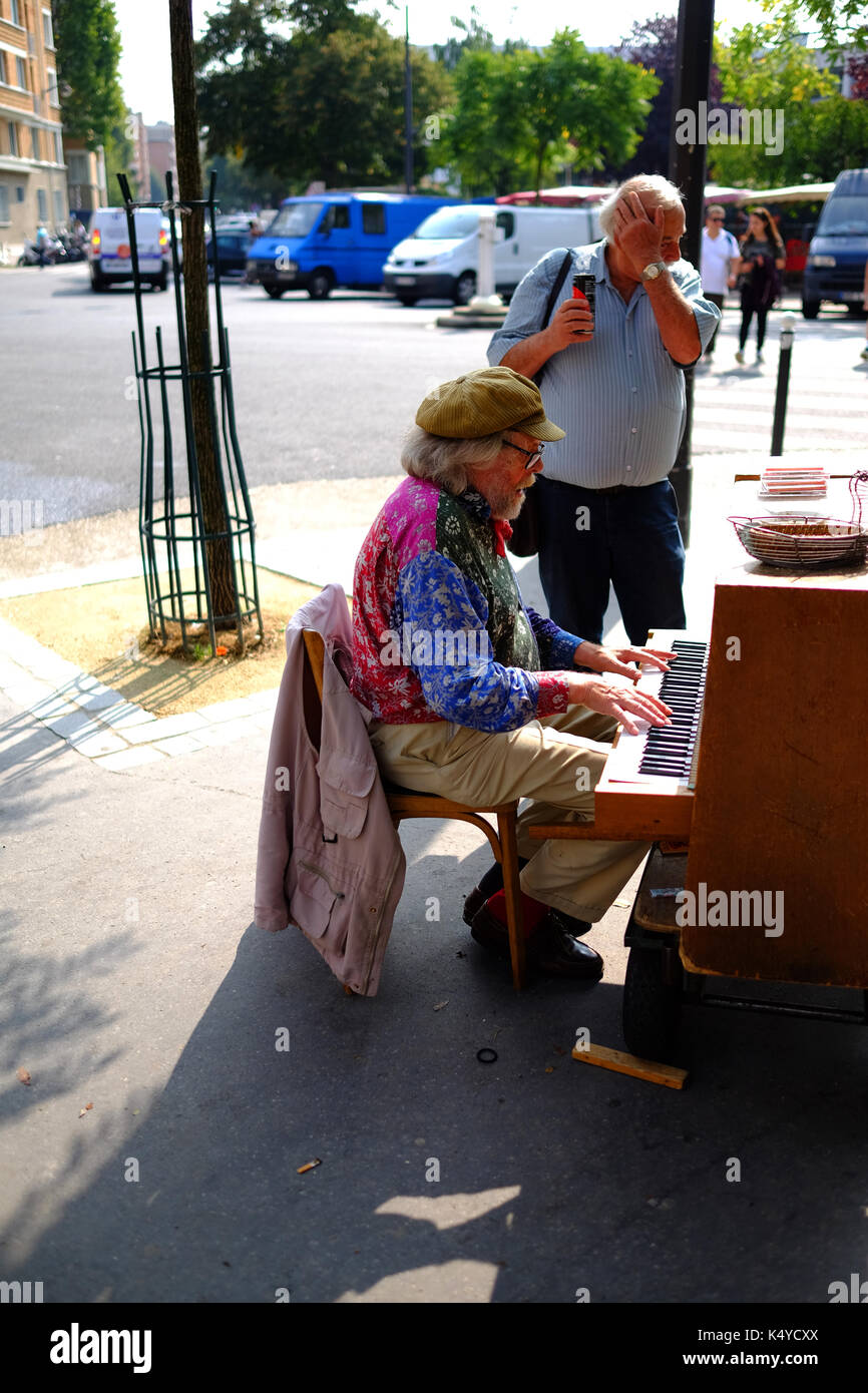 Un musicista di strada a suonare il pianoforte vicino al mercato di antiquariato si spegne nelle Marche aux Puces, il mercato delle pulci, Porte de Vanves a Parigi Foto Stock