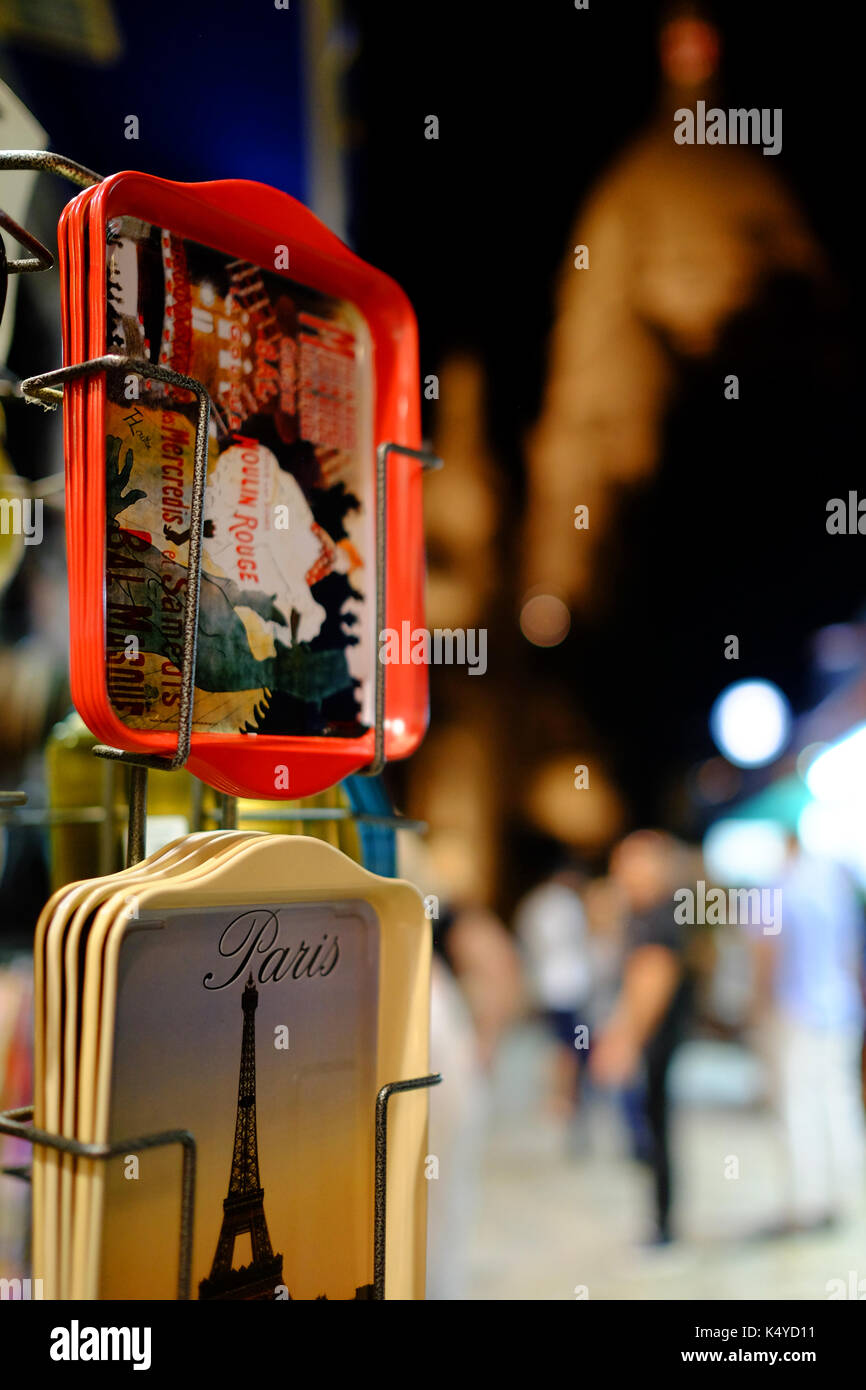 Souvenir turistici sulla vendita di notte in Montmartre, Parigi con il Sacre Coeur in background Foto Stock