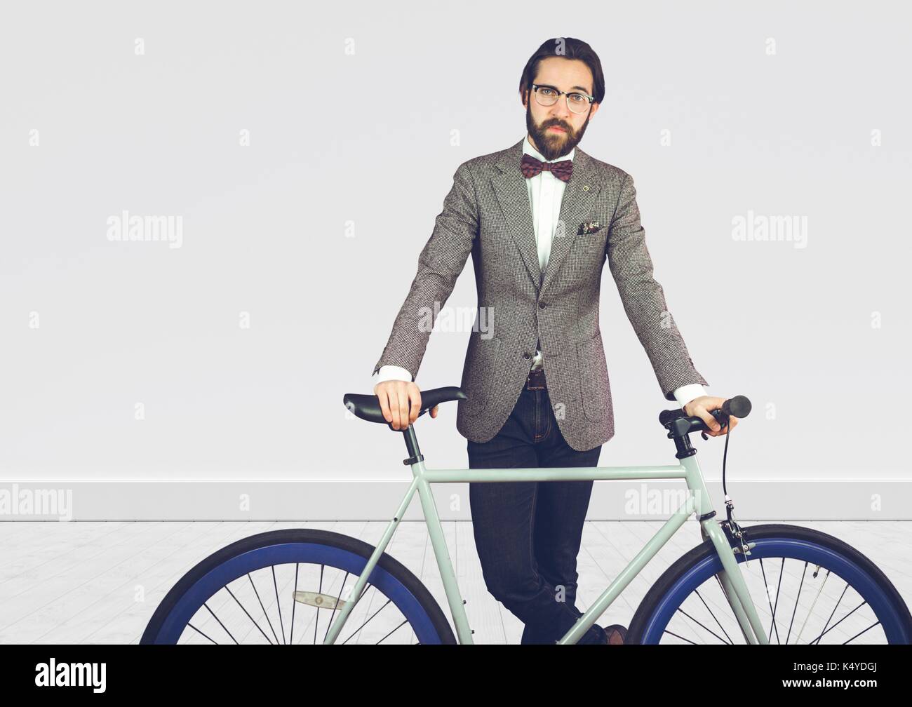 Digital composito della millenaria uomo in tuta con moto contro il muro bianco Foto Stock