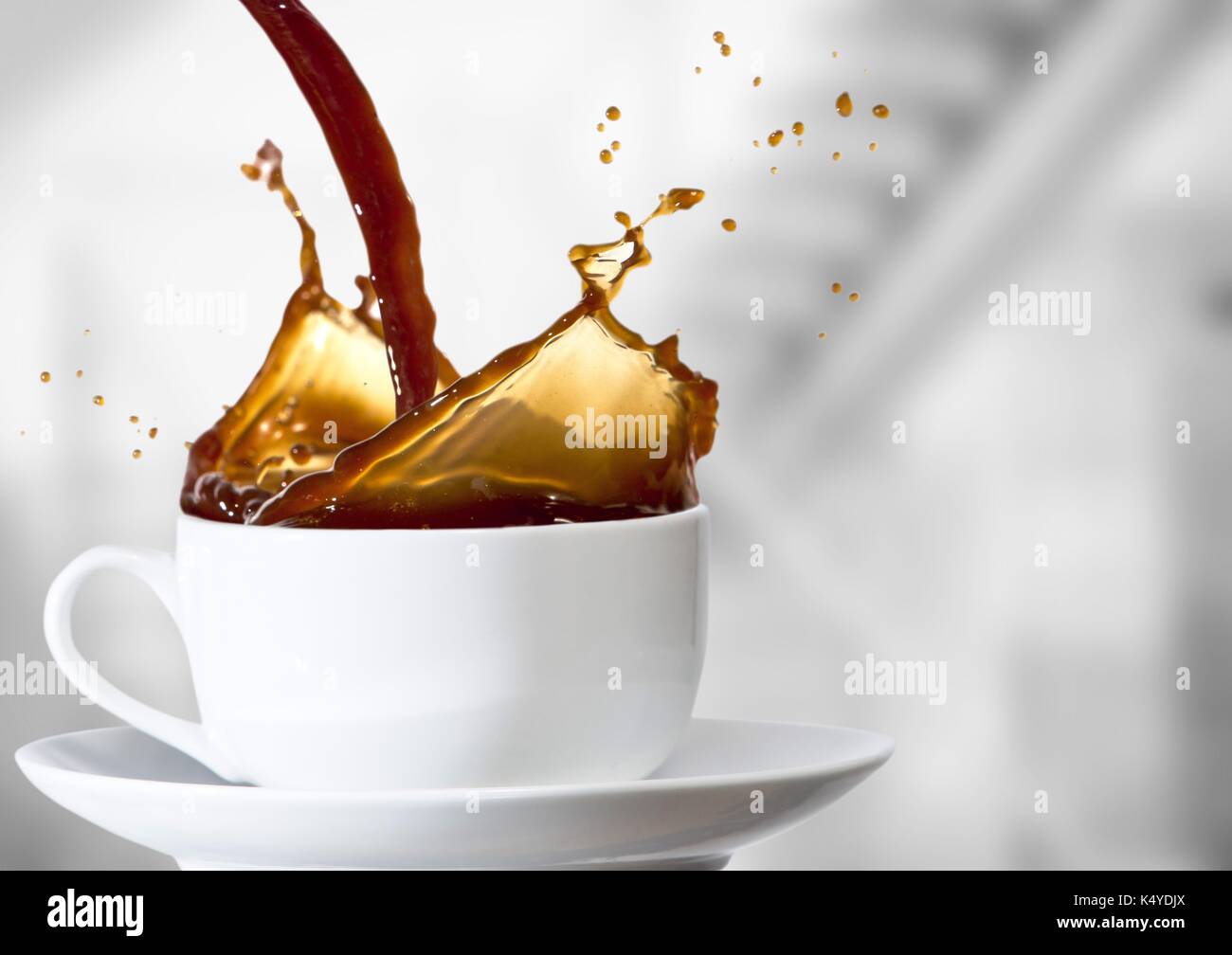 Composito Digitale del caffè è versata nella tazza bianca contro sfocate scale di grigio Foto Stock