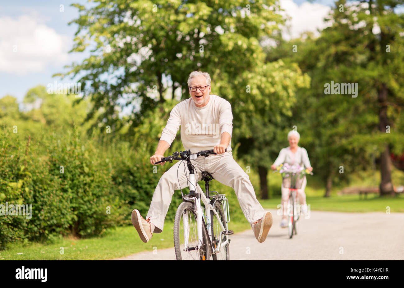 Terza età attiva, le persone e il concetto di stile di vita - felice coppia senior equitazione biciclette al summer park Foto Stock