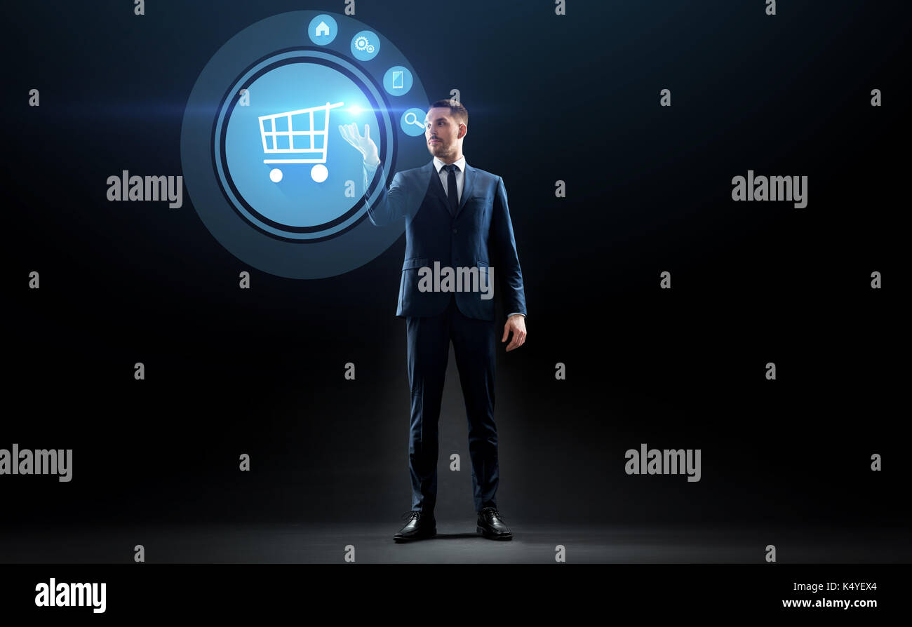 Imprenditore con carrello su schermo virtuale Foto Stock