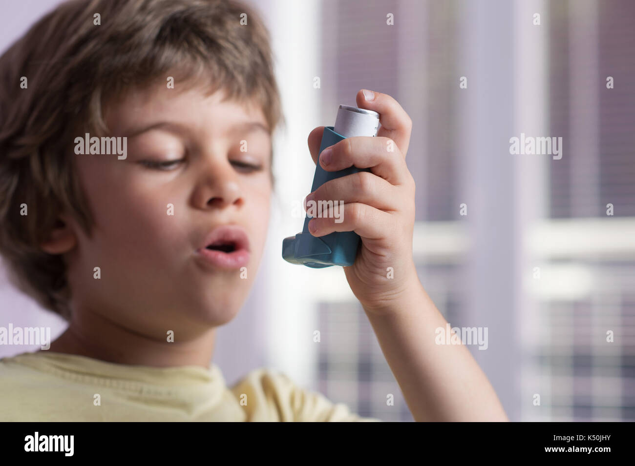 Boy utilizzando l'asma inalatore per trattare malattie infiammatorie, dispnea, tosse e di tenuta al torace e mancanza di respiro. allergia al concetto di trattamento. selet Foto Stock