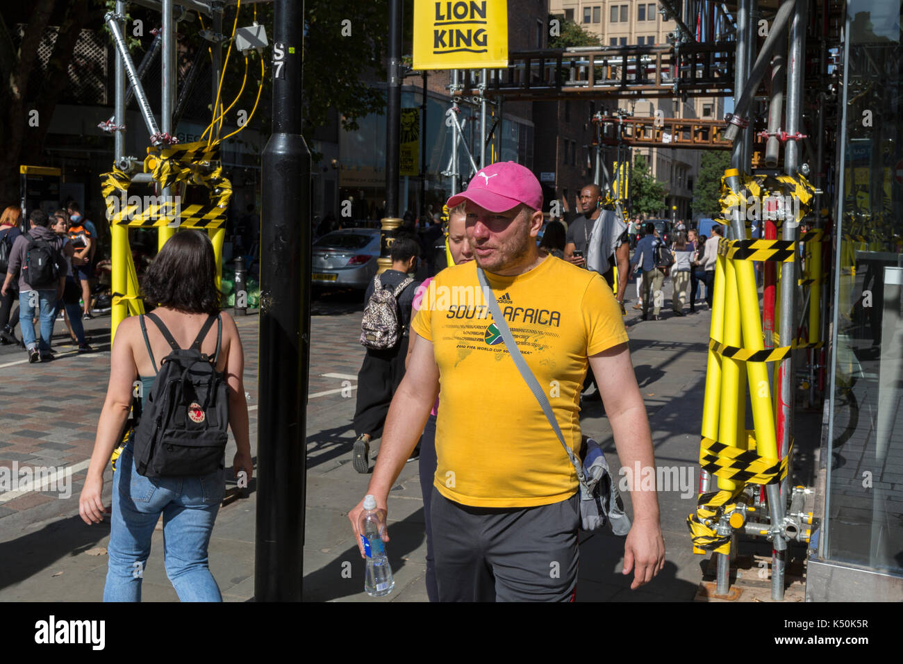 Occupato angolo di strada con giallo ponteggio manicotti di protezione e passaggio di pedoni su Long Acre vicino a Covent Garden, il 1° settembre 2017, a Londra, in Inghilterra. Foto Stock