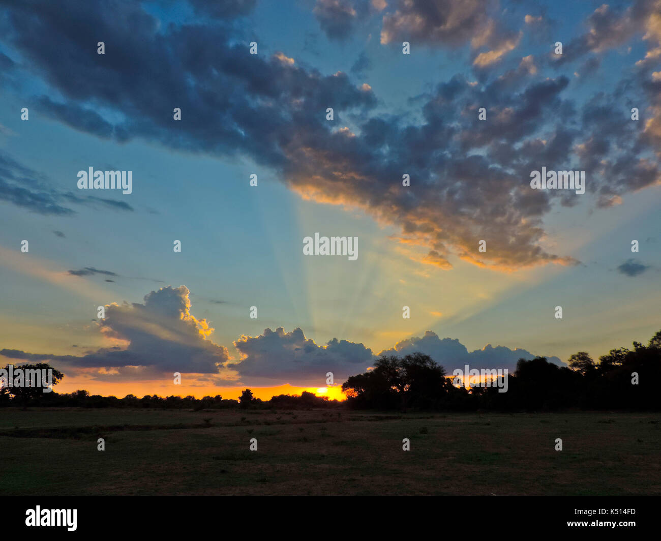 Bel tramonto con raggi di luce la colata attraverso il cielo sopra il fiume LUANGWA, vicino MFUWE bush camp, SOUTH LUANGWA NATIONAL PARK, ZAMBIA Foto Stock