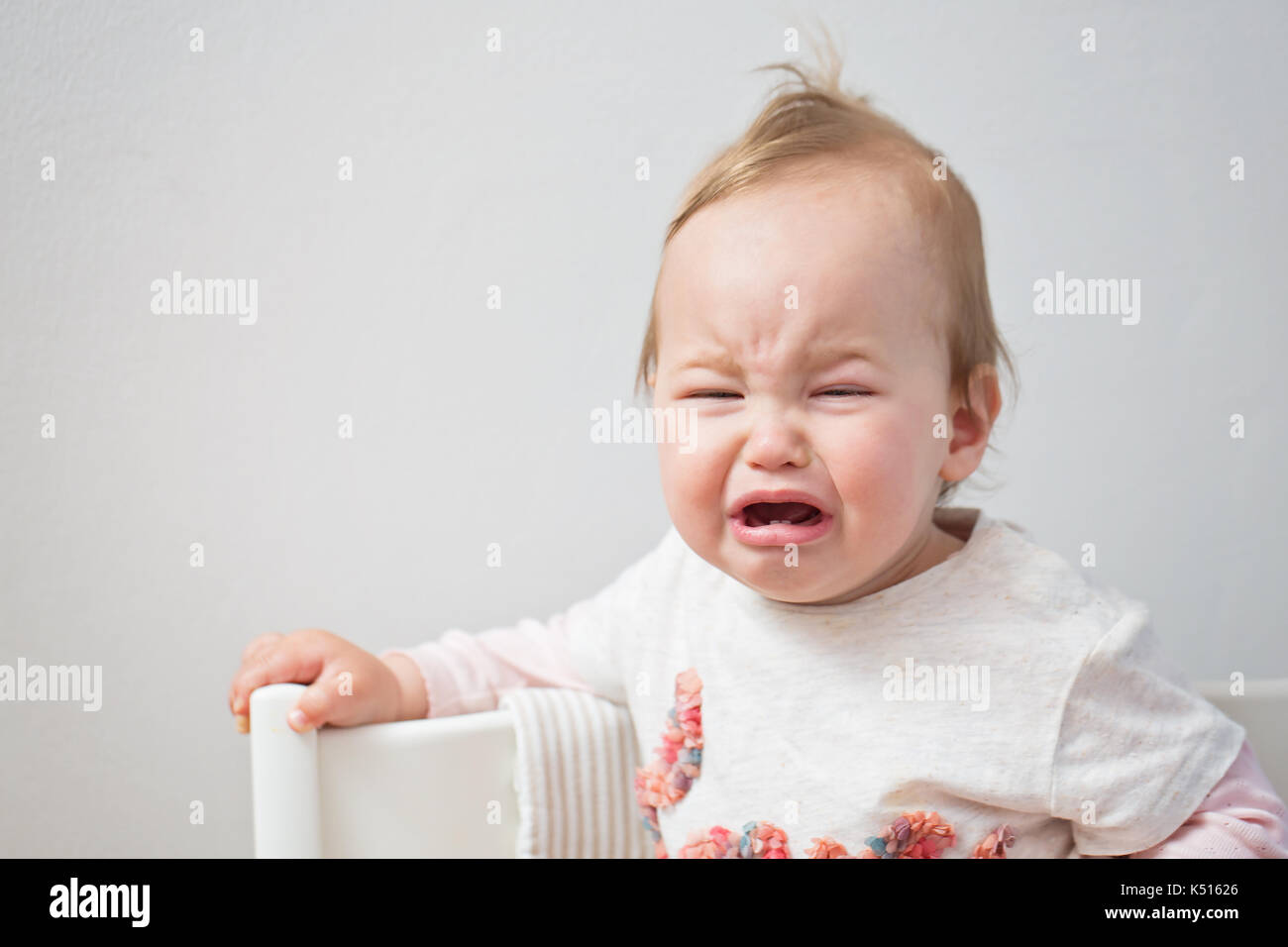 Un anno di età del bambino piangere ragazza pur essendo orinato Foto Stock