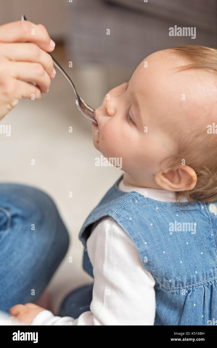 Alimentazione madre bambina; nozione di vita familiare, mangiare sano e Baby nutrizione Foto Stock