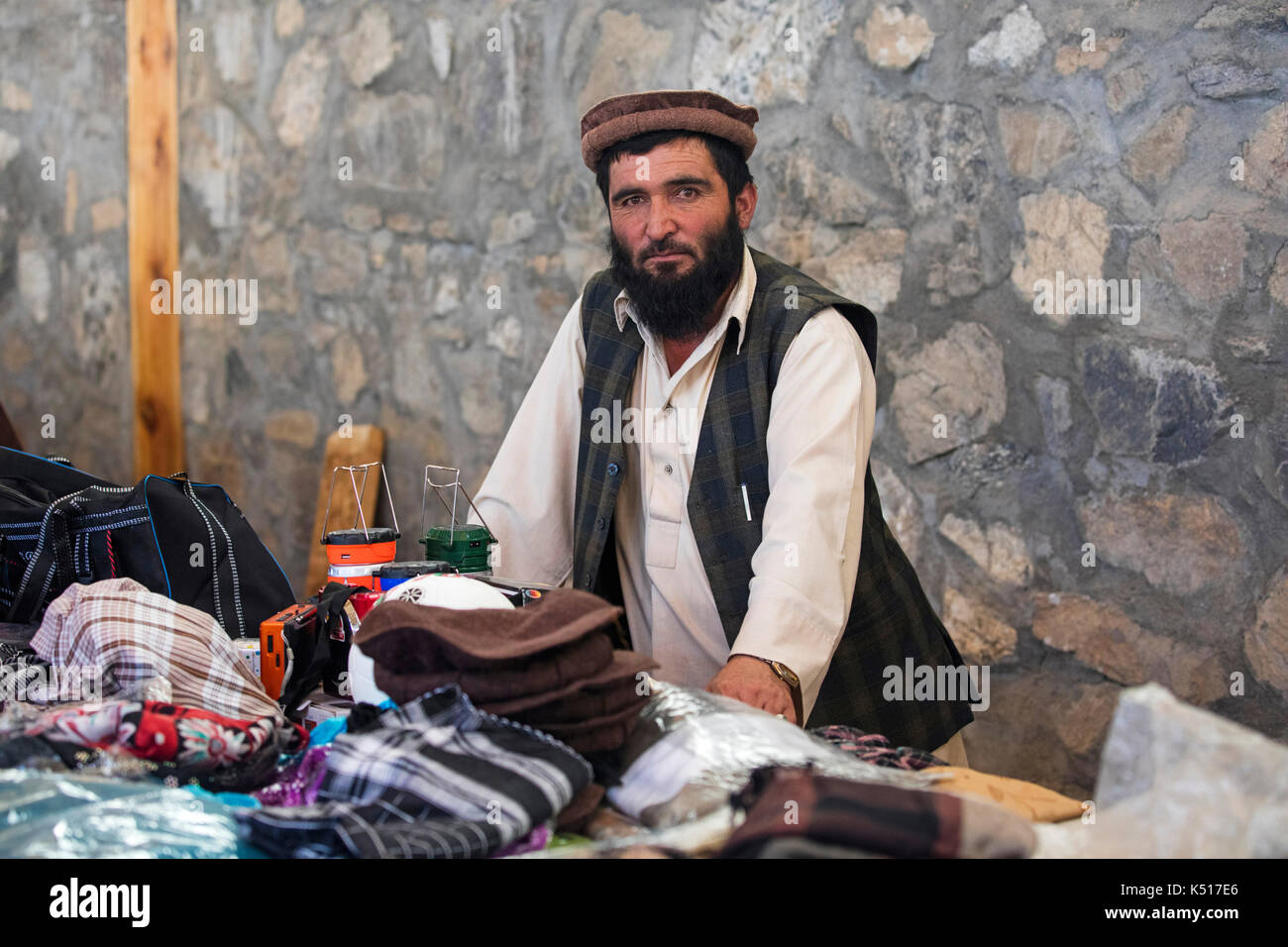 Trader afghano che vende merci al mercato di sabato / mercato di amicizia tagico-afghano a Khorugh, capitale di Gorno-Badakhshan in Tagikistan Foto Stock