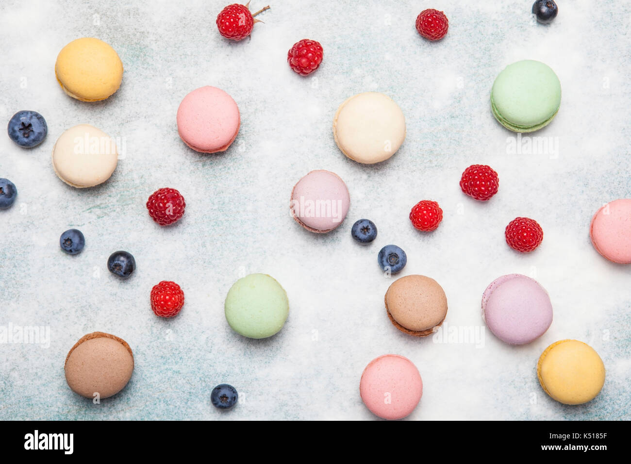 Varietà di coloratissimi dolce francese dessert - makaron ( les macarons) con fiori autunnali e bacche. Foto Stock