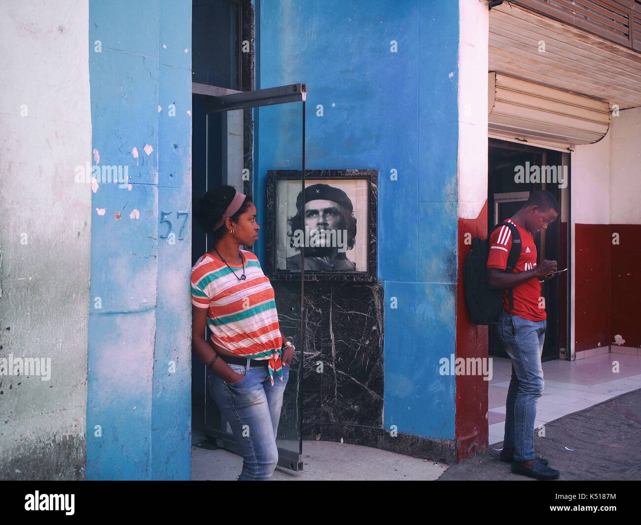 I giovani nel vestibolo di un edificio a l'Avana con una foto di Che Guevara Foto Stock