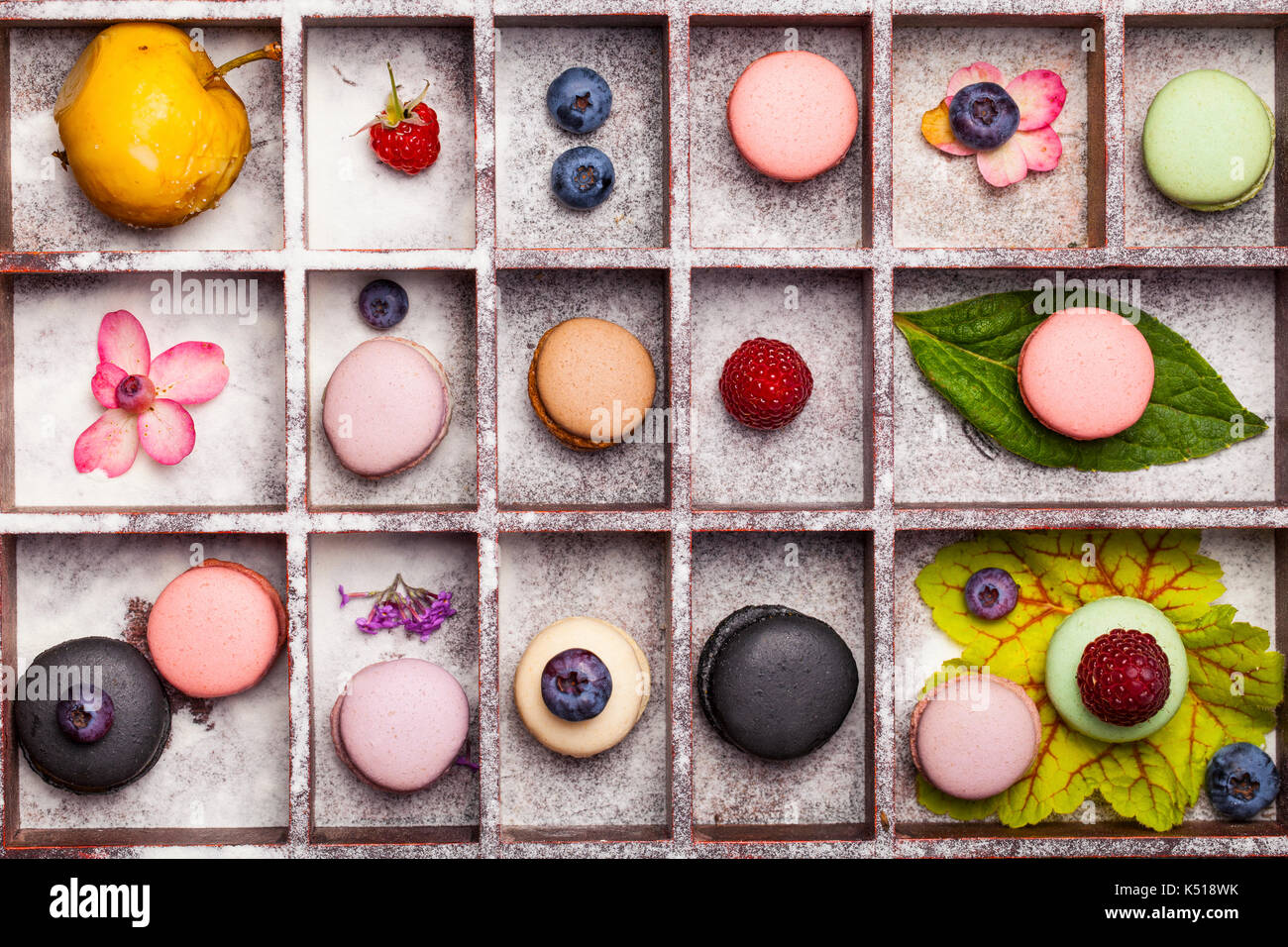 Varietà di coloratissimi dolce francese dessert - makaron ( les macarons) con fiori autunnali e bacche. Foto Stock