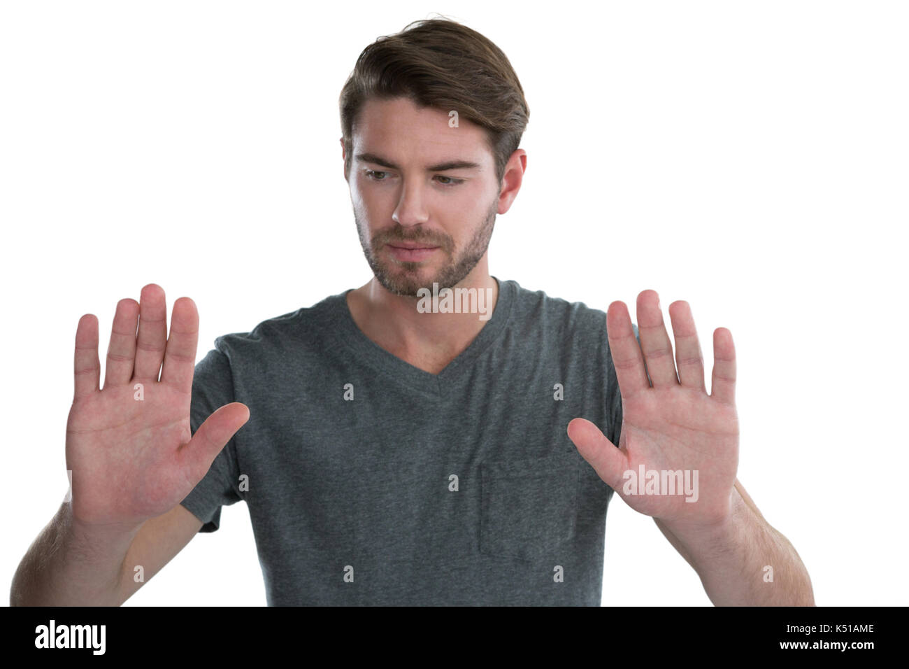 L'uomo fingendo di toccare una schermata invisibile contro uno sfondo bianco Foto Stock