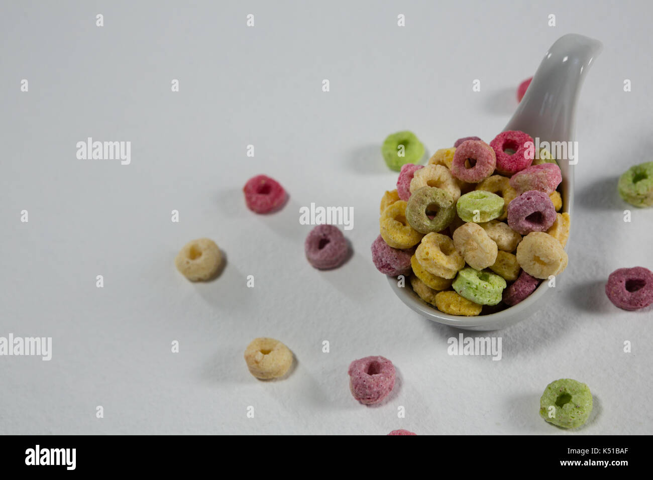 Froot loops in cucchiaio su sfondo bianco Foto Stock