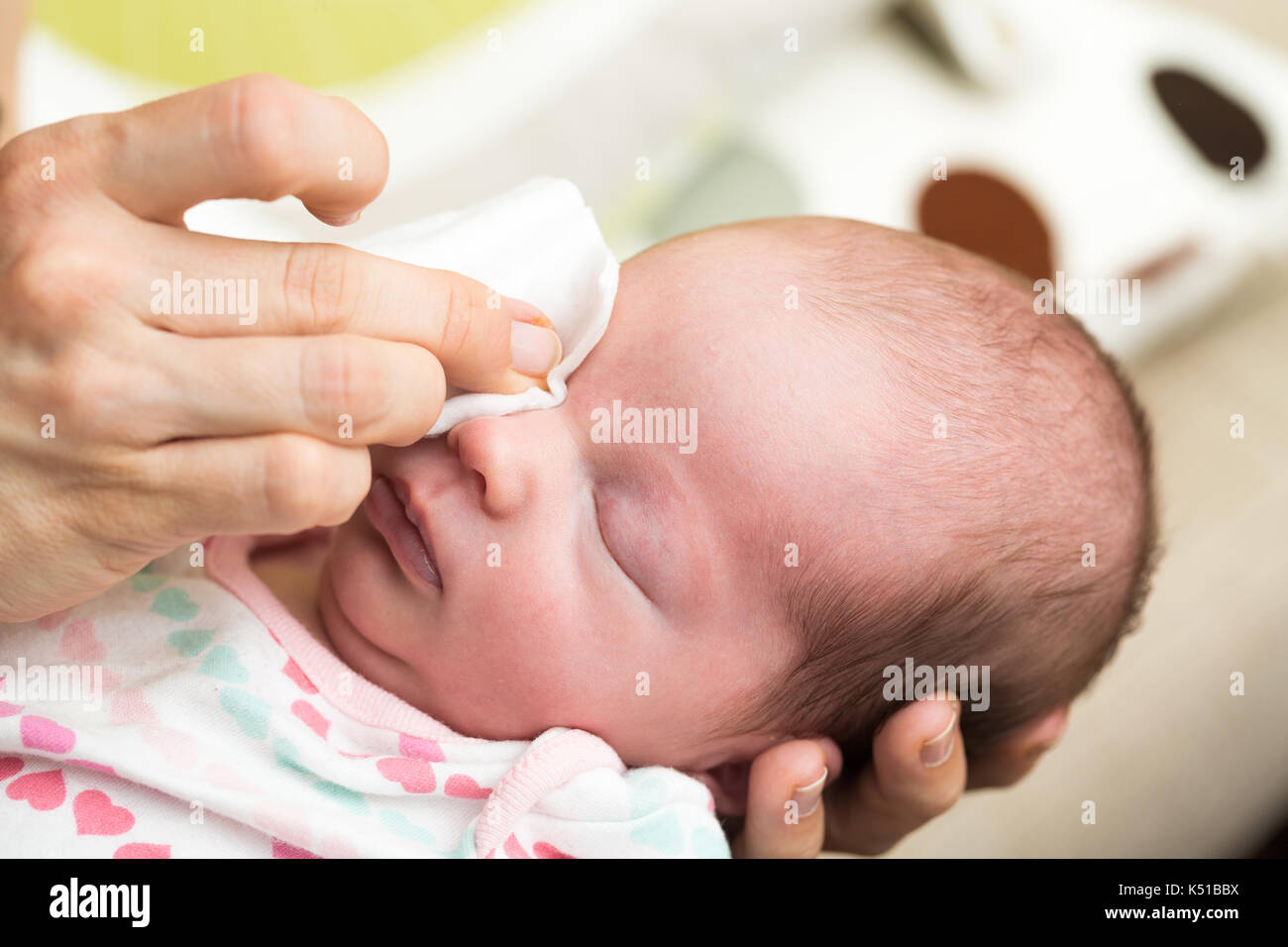 La madre gli occhi per la pulizia di un neonato con soluzione fisiologica  su una striscia di cotone Foto stock - Alamy