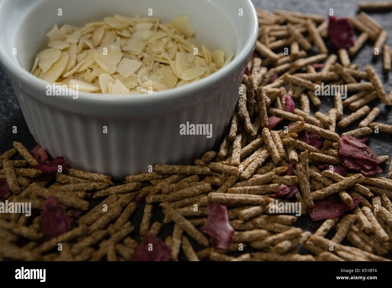 Tazza di crusca di mais con crusca di cereali stick sparsi sul tavolo Foto Stock