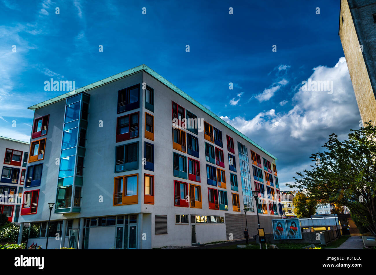 Simbolo colorato di arte moderna / Architettura, anziani home in città urban area con facciata di brillanti colori. drammatico cielo sopra gli edifici esterno Foto Stock